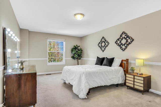 bedroom with light colored carpet and baseboards
