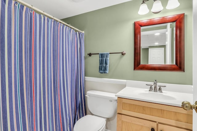 bathroom with toilet, vanity, and curtained shower