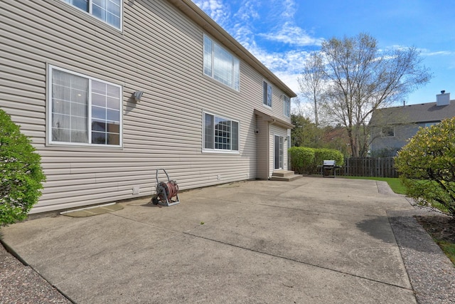 rear view of house with a patio and fence