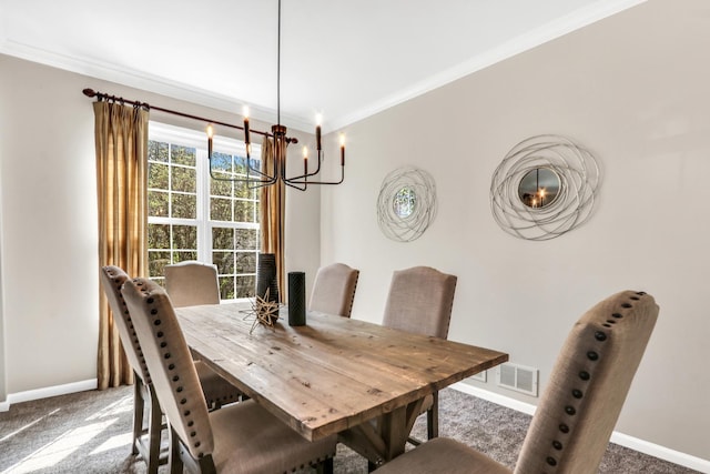 carpeted dining room featuring baseboards, a chandelier, and crown molding