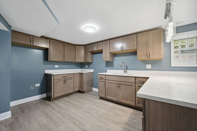 1235 N Mason Ave, Chicago, IL 60651 - kitchen featuring a sink, baseboards, light wood finished floors, and light stone countertops