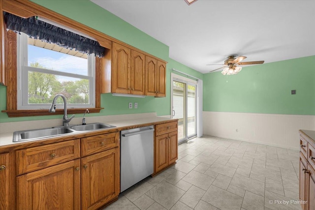 3700 Theodore St, Joliet, IL 60431 - kitchen with stainless steel dishwasher, a sink, ceiling fan, wainscoting, and brown cabinets