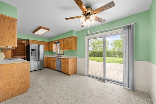 3700 Theodore St, Joliet, IL 60431 - kitchen with appliances with stainless steel finishes, light countertops, ceiling fan, brown cabinetry, and a sink
