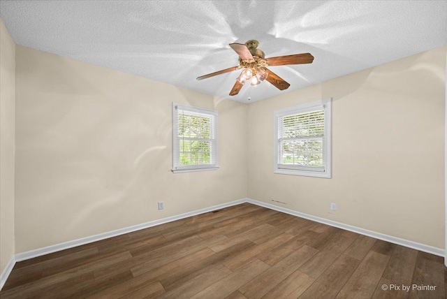 3700 Theodore St, Joliet, IL 60431 - empty room with dark wood-style flooring, baseboards, a ceiling fan, and a textured ceiling