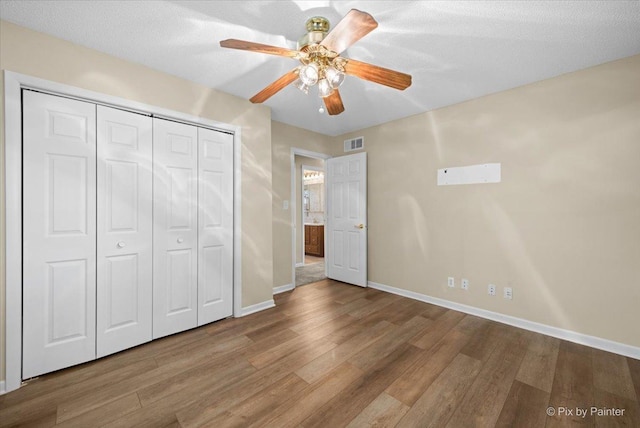 3700 Theodore St, Joliet, IL 60431 - unfurnished bedroom with wood finished floors, baseboards, a closet, and a ceiling fan