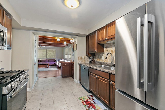 616 Kirk Ave, Elgin, IL 60120 - kitchen featuring appliances with stainless steel finishes, a sink, light tile patterned floors, tasteful backsplash, and dark countertops