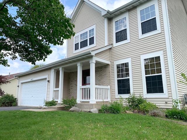 1453 Bluestem Ln, Minooka, IL 60447 - view of front of home featuring a porch, a front yard, a garage, and driveway