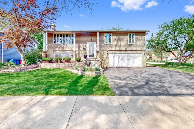 1156 N Fischer Dr, Addison, IL 60101 - split foyer home featuring a garage, asphalt driveway, a chimney, a front lawn, and brick siding