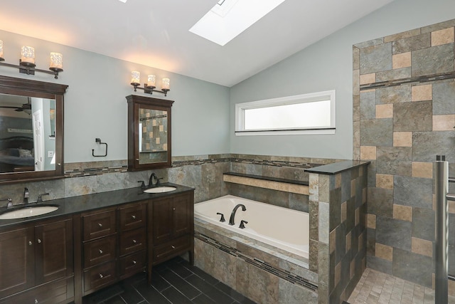 bathroom with vaulted ceiling, a skylight, a garden tub, double vanity, and tiled shower