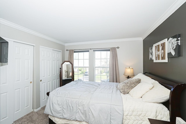 carpeted bedroom featuring two closets and crown molding