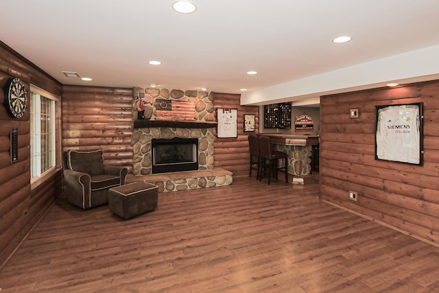 living area with a fireplace, log walls, wood finished floors, and recessed lighting