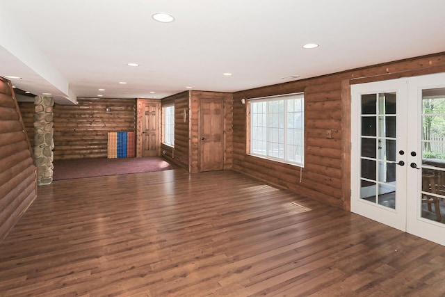 unfurnished living room with rustic walls, wood finished floors, french doors, and recessed lighting