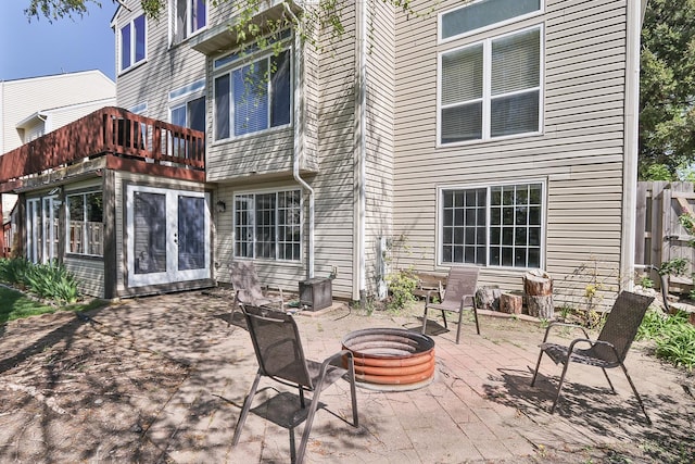 view of patio / terrace featuring a fire pit, french doors, and a balcony