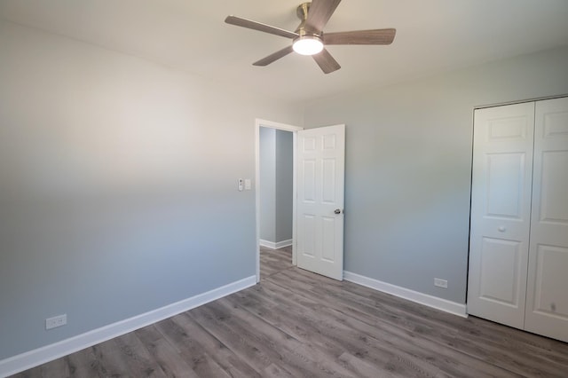 unfurnished bedroom with wood finished floors, baseboards, a closet, and ceiling fan