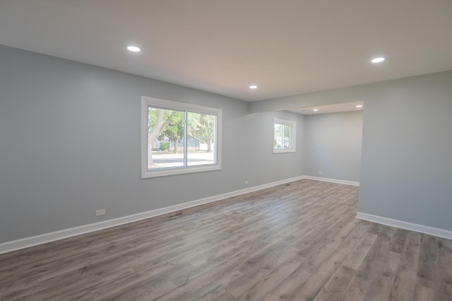 spare room with recessed lighting, wood finished floors, and baseboards