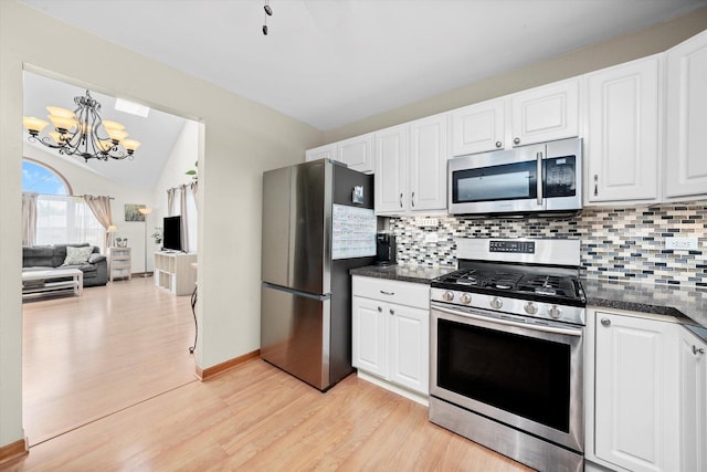 5157 Ribbon Ct, Monee, IL 60449 - kitchen featuring appliances with stainless steel finishes, dark countertops, a chandelier, light wood-style floors, and lofted ceiling