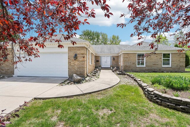 ranch-style house featuring driveway, brick siding, a garage, and a front yard