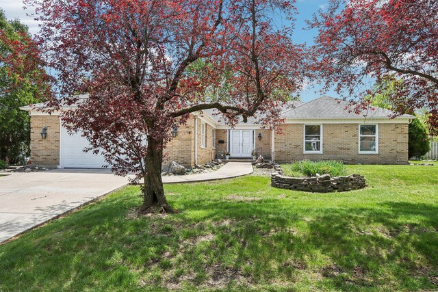 view of front of home featuring concrete driveway, an attached garage, brick siding, and a front lawn
