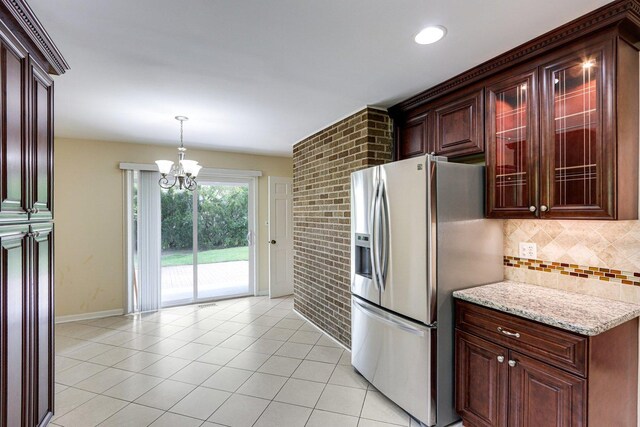kitchen featuring stainless steel fridge with ice dispenser, tasteful backsplash, light tile patterned flooring, a chandelier, and hanging light fixtures