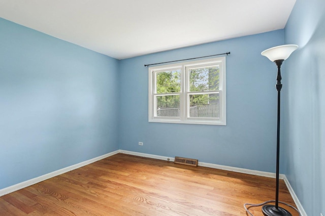 empty room featuring light wood finished floors and baseboards