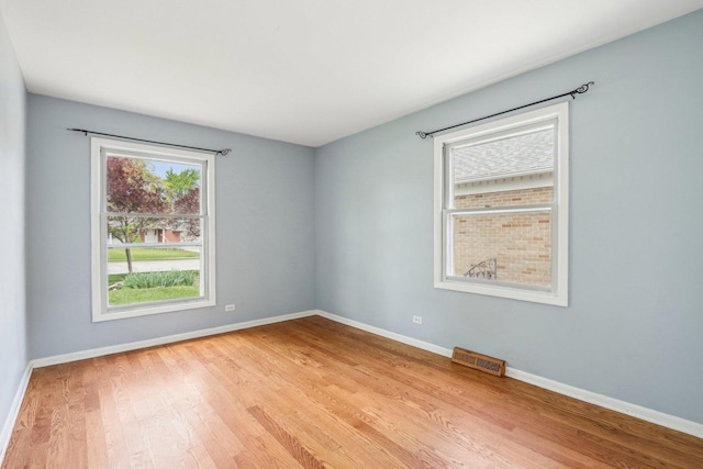 empty room featuring light wood finished floors and baseboards