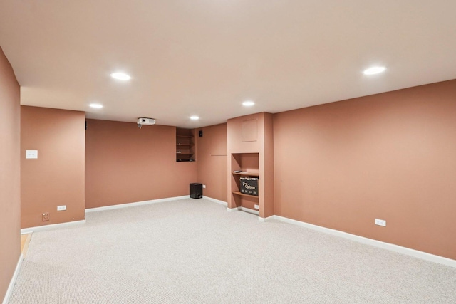 finished below grade area featuring recessed lighting, light colored carpet, and baseboards
