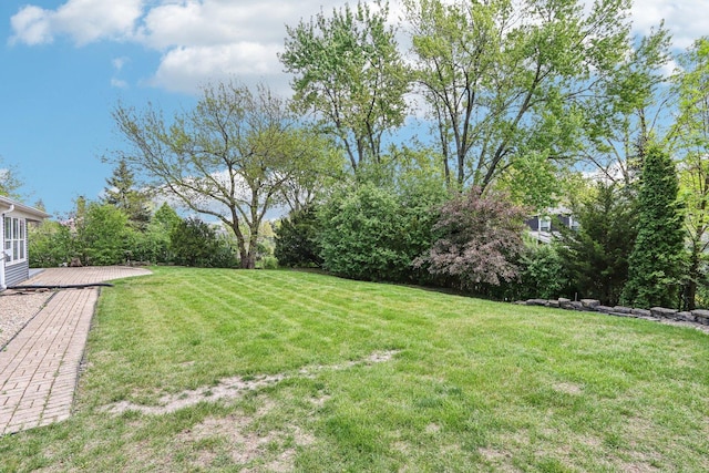 view of grassy yard with a wooden deck