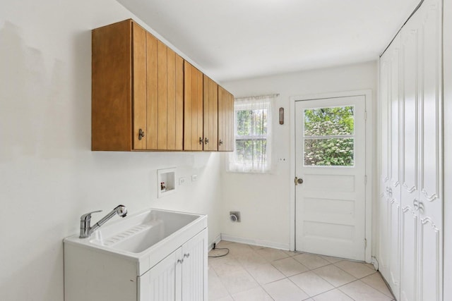 laundry room with cabinet space, hookup for a washing machine, baseboards, electric dryer hookup, and light tile patterned floors