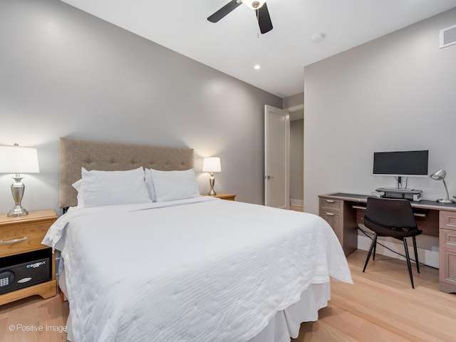 bedroom featuring light wood-style floors, an office area, and ceiling fan