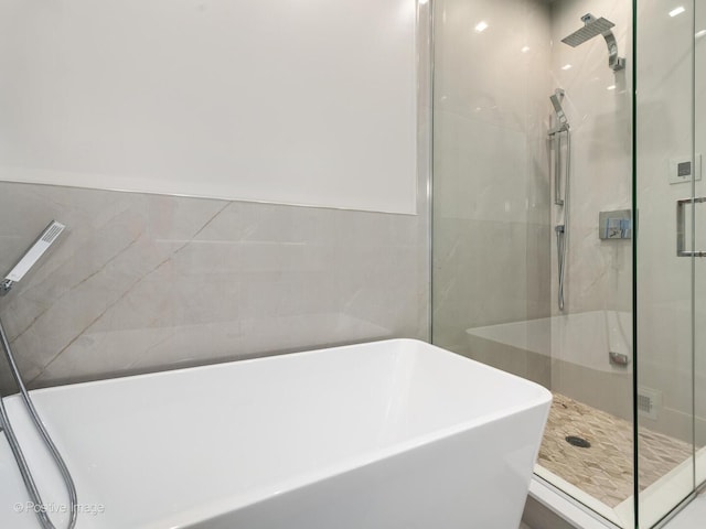 full bathroom with a stall shower and a soaking tub