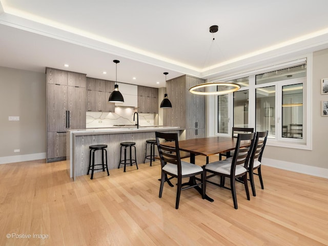 dining area with light wood finished floors, baseboards, and recessed lighting