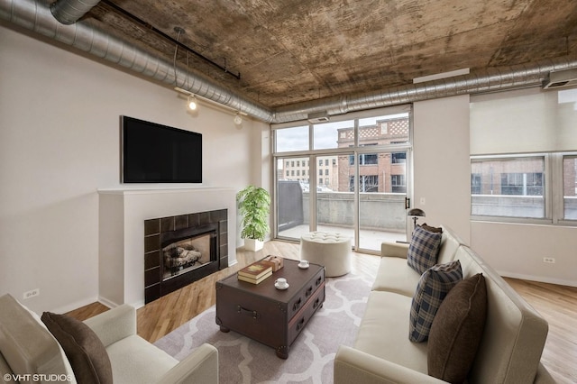 living area featuring a fireplace, wood finished floors, and baseboards