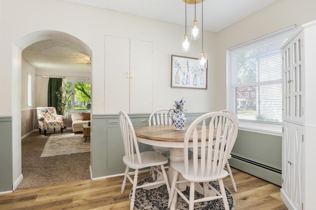 315 W Bennett St, Pontiac, IL 61764 - dining area with a baseboard radiator, light wood-type flooring, arched walkways, and baseboards