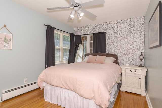 315 W Bennett St, Pontiac, IL 61764 - bedroom with baseboard heating, light wood finished floors, wallpapered walls, ceiling fan, and baseboards