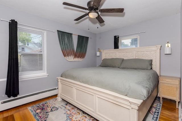 315 W Bennett St, Pontiac, IL 61764 - bedroom featuring a baseboard radiator, wood finished floors, multiple windows, and ceiling fan