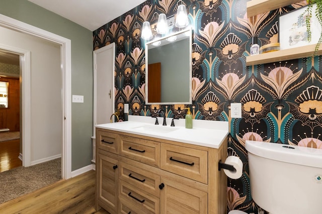 315 W Bennett St, Pontiac, IL 61764 - bathroom with wood finished floors, vanity, baseboards, wallpapered walls, and toilet