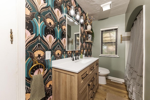 315 W Bennett St, Pontiac, IL 61764 - bathroom with wood finished floors, toilet, vanity, baseboards, and a textured ceiling