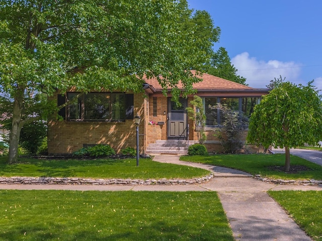 315 W Bennett St, Pontiac, IL 61764 - view of front of property with brick siding, a front lawn, and a carport