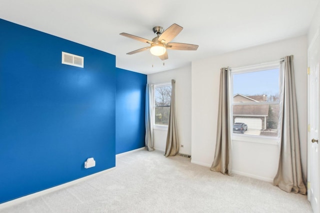 spare room featuring a ceiling fan, carpet flooring, and baseboards