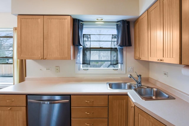 kitchen featuring stainless steel dishwasher, light countertops, light brown cabinets, and a sink