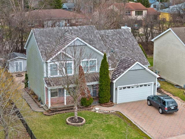 513 Trestle Ct, Grayslake, IL 60030 - view of front of property featuring a garage, decorative driveway, a front lawn, an outbuilding, and a storage shed