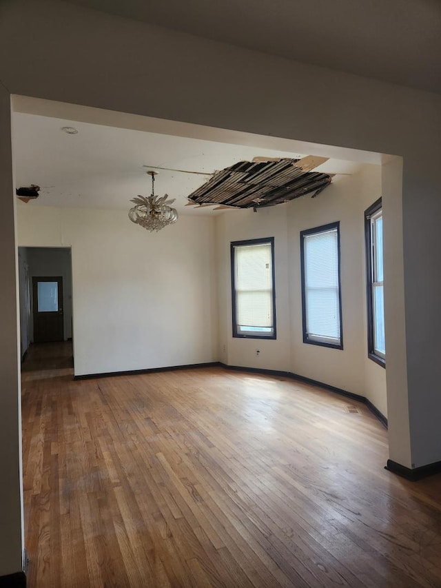 10435 S Calhoun Ave, Chicago, IL 60617 - empty room with hardwood / wood-style floors, baseboards, and a chandelier