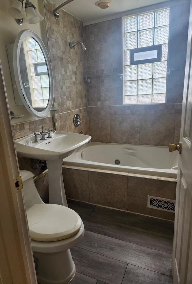 10435 S Calhoun Ave, Chicago, IL 60617 - full bathroom with wood finished floors, toilet, tiled shower / bath combo, and plenty of natural light