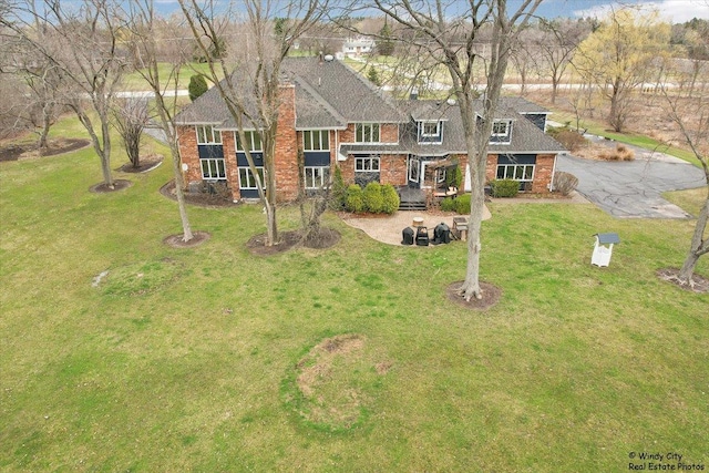 1375 Atkinson Rd, Green Oaks, IL 60048 - view of front of house with brick siding, a front yard, and a shingled roof