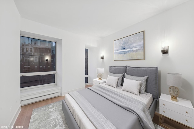 bedroom with wood finished floors and baseboards