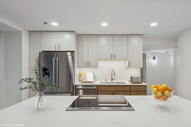 kitchen with a sink, stainless steel appliances, light countertops, and recessed lighting