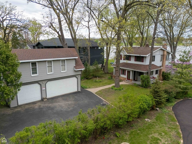 view of front of property featuring driveway, a garage, and a shingled roof