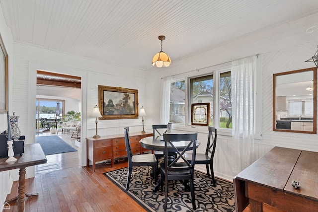 dining room with wood-type flooring and wooden ceiling