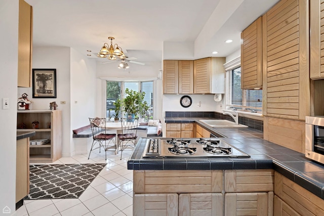 kitchen with stainless steel gas cooktop, a sink, plenty of natural light, light brown cabinets, and recessed lighting