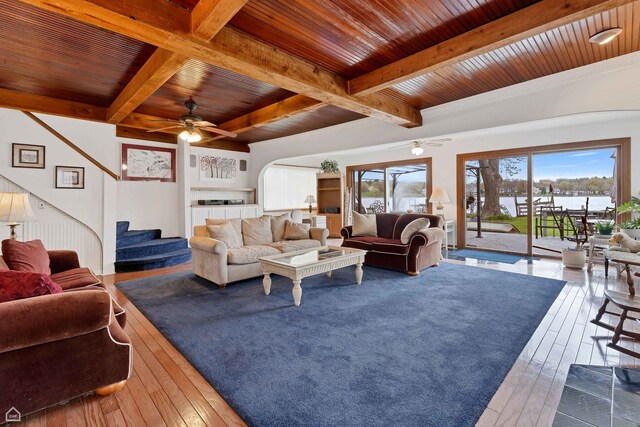 living room with wood ceiling, a ceiling fan, beamed ceiling, stairs, and hardwood / wood-style flooring